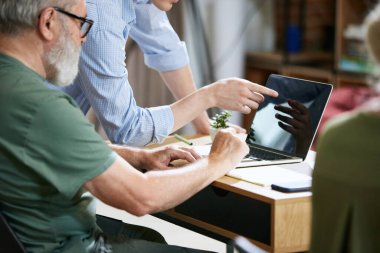 Genç bir adam, üst düzey çalışanları, profesyonel sorunları olan üniversiteleri sunum için dizüstü bilgisayar uygulamalarını kullanmayı öğretiyor. İş, eğitim, modernlik, yenilikler, yardım kavramı