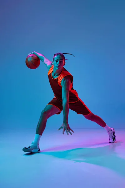 Skoncentrowany Młodzieniec Odzieży Sportowej Grający Koszykówkę Ćwiczący Dryblowanie Piłką Niebieskim — Zdjęcie stockowe