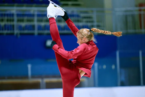 灵活而艺术的女孩 花样滑冰运动员在红色运动服的训练 在冰场上做运动 职业体育 体育学校 业余爱好 广告的概念 — 图库照片