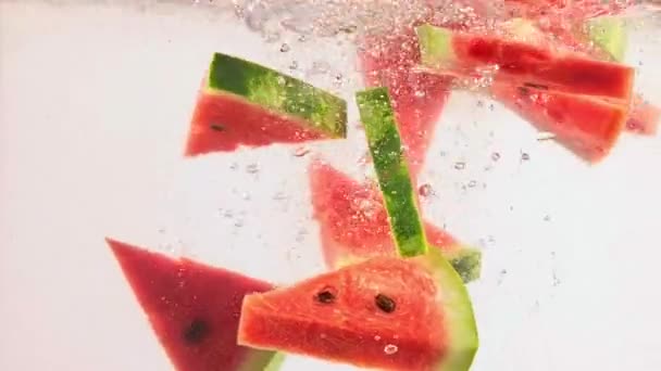 Frische Wassermelonenscheiben Fallen Vor Weißem Hintergrund Ins Wasser Sommergeschmack Und — Stockvideo