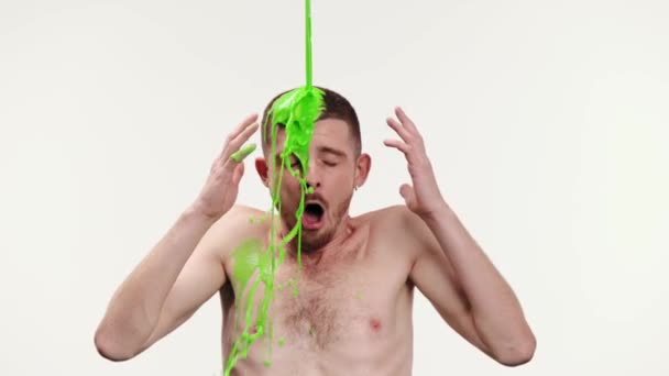白いスタジオの背景に対して濃い緑のペンキで覆われているエモーショナルで若く シャツのない男 リフレッシュメント 人体に関する抽象芸術 創造性 インスピレーションの概念 — ストック動画