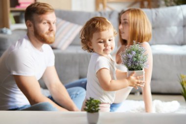 Güzel genç bir çift, ebeveynler küçük kızla, kızlarıyla evde vakit geçiriyorlar. Bebek bekleyen bir kadın. Hamilelik, aile, aşk, ilişki, ebeveynlik ve çocukluk kavramı