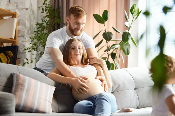 Stock image Support and care. Loving man, husband holding hand on his wife belly. Couple spending time at home together. Concept of pregnancy, family, love, relationship, parenthood and childhood