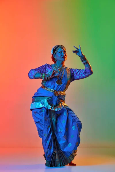 Odissi舞蹈 在霓虹灯下 穿着传统服饰跳舞的漂亮而成熟的印度女人在渐变工作室的背景下跳印第安舞 艺术的概念 — 图库照片