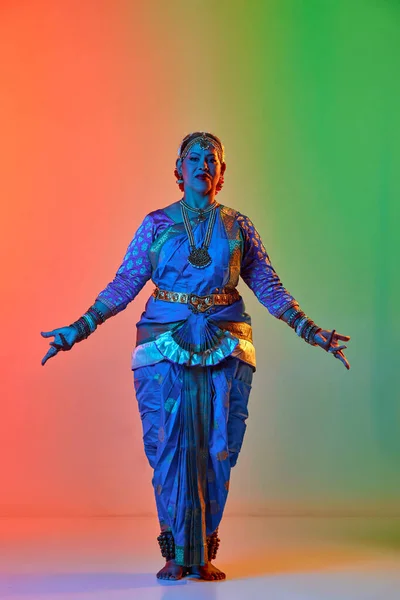 在霓虹灯下 美丽的印度女人穿着雅致的蓝色衣服在渐变工作室的背景下跳着传统的舞蹈 美的概念 — 图库照片