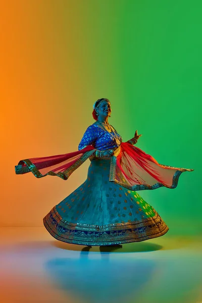 在霓虹灯下 穿着传统印度服装的美丽 成熟的印度女人在渐变的工作室背景下跳舞 美的概念 — 图库照片
