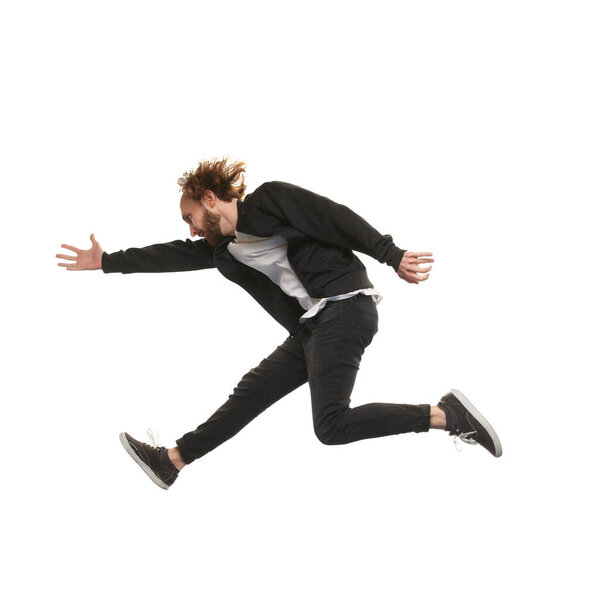 Young man in casual clothes jumping isolated on white background. Ambitions and motivation for growth. Concept of youth, active lifestyle, motivation, emotions and facial expression. Ad