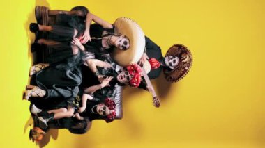 Yaratıcı aile, erkek, kadın ve makyajlı iki kız çocuğu sarı stüdyo arka planında şarkı söylüyorlar. Cadılar Bayramı kavramı, El Dia de Muertos, bayramlar ve festivaller, Meksika gelenekleri, aile