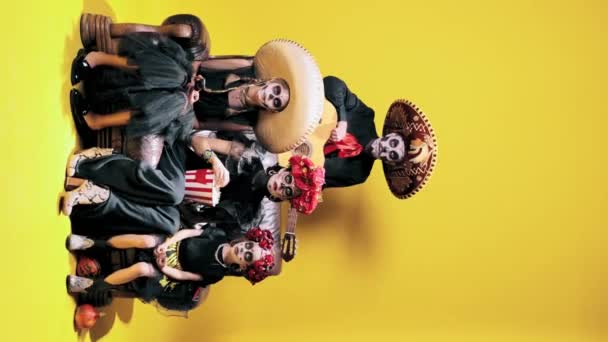 年轻的男人 戴着糖衣的女儿 穿着服装观看黄色背景的恐怖片 Hallobetween Dia Muertos Holidays Festivals Mexican Traditions — 图库视频影像