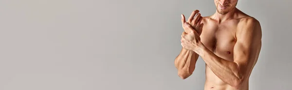 剪裁的形象肌肉男子与舒缓的身体在内裤拿着手腕灰色背景 男人的健康和美的概念 身体护理 班纳广告的复制空间 — 图库照片