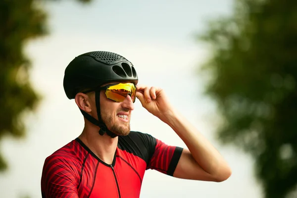 Mature man, sportsman in helmet and goggles training outdoors. Riding bicycle, marathon. Concept of professional sport, triathlon preparation, competition, athleticism