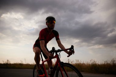 Rekabetçi bir adam, dışarıda bisiklet süren bir triatloncu, maratona hazırlanıyor. Profesyonel spor anlayışı, triatlon hazırlığı, rekabet, atletizm