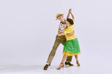 Lala, lindy hop. Güzel, şık genç mana ve beyaz stüdyo arka planında yalnız dans eden kadın. Sanat konsepti, hobi, retro dans, klasik tarz, koreografi, güzellik. Ad