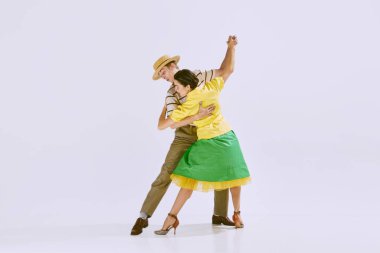 Lala, lindy hop. Güzel, şık genç mana ve beyaz stüdyo arka planında yalnız dans eden kadın. Sanat konsepti, hobi, retro dans, klasik tarz, koreografi, güzellik. Ad