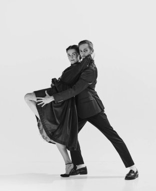 Ritim ve özgürlük. Siyah ve beyaz. Zarif siyah elbiseli güzel bir kadın şık ve yakışıklı bir adamla dans ediyor. Hobi anlayışı, retro dans, klasik stil, koreografi. Monokrom sanatı. Ad