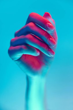 Yumuşaklık. Zarif kadın eli mavi arka planda neon ışıkta izole edilmiş. Doğal, çıplak tırnaklar, manikür. El bakımı, kozmetik ve kozmetik kavramı, spa, doğal güzellik. Poster, reklam