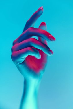 Çıplak, doğal tırnakları olan zarif ve iyi korunmuş bir kadın eli. Mavi arka planda izole edilmiş bir manikür. El bakımı, kozmetik ve kozmetik kavramı, spa, doğal güzellik. Poster, reklam