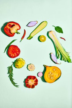 Açık arkaplanda taze, dilimlenmiş sebzelerin üst görüntüsü. Balkabağı, biber, domates, soğan, kabak. Sebze, bahçe, hasat, organik gıda, çiftçi pazarı ve yiyecek kavramı. İlan için alanı kopyala
