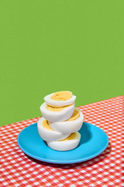 Sliced Hard Boiled Eggs Blue Plate Checkered Tablecloth Green Background — Stock Photo, Image