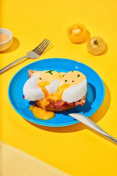Poached eggs and bacon on toasted bun on plate over yellow background. Yummy. Concept of breakfast, food, taste, health, creativity. Pop art photography. Poster. Copy space for ad