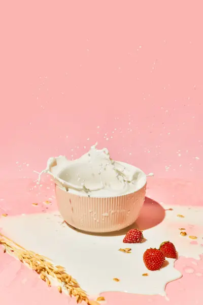 Sweet and healthy. Bowl with splashing milk, cereal, muesli and berries against pink background. Healthy breakfast. Concept of healthy food, nutrition, pop art style, taste. Poster. Copy space for ad