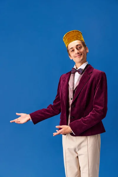 Willkommen Positiver Junger Mann Träger Glockenjunge Kostüm Vor Blauem Studiohintergrund — Stockfoto