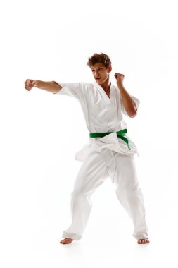 Genç adam, karate, judo, tekvando sporcusu, antrenman, dövüş, beyaz stüdyo geçmişi. Dövüş sanatları kavramı, dövüş sporu, enerji, güç, sağlık. Ad