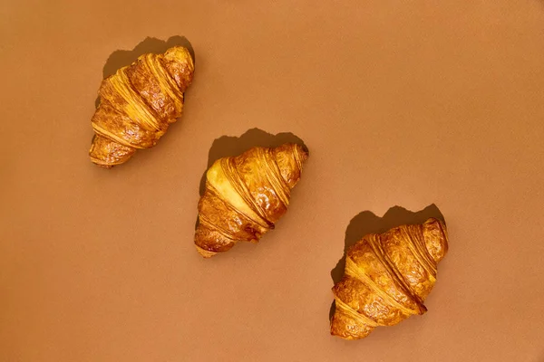 Three Crispy Freshly Baked Croissants Isolated Brown Background Yummy Taste — Stock Photo, Image
