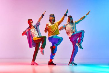 Klasik giyinmiş, renkli spor kıyafetleri giyen erkekler, neon ışıkta, gradyan pembe arka plana karşı aerobik egzersizleri yapıyorlar. Sportif ve aktif yaşam tarzı, mizah, eski tarz kavramı. Ad