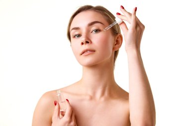 Çekici, bakımlı, sağlıklı, pürüzsüz bir cildi olan, yüz serumu kullanan, nemlendirici ve beyaz arka plan üzerinde deriyi koruyan genç bir kız. Doğal güzellik kavramı, cilt bakımı, kozmetik ve kozmetik.