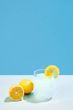 İçecek bir şeyler. Mavi arka planda izole edilmiş limonlu ve şekerli tatlı ve ekşi kokteyl. İçki, parti, tatil, kokteyl, kokteyl kavramı. Poster. İlan için alanı kopyala