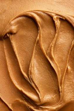 Pürüzsüz fıstık ezmesi dokusunun yakın çekimi. Kahvaltı tostları ve krepler için açık kahverengi tatlı macun. Yiyecek, kahvaltı, sağlıklı beslenme ve atıştırmalıklar, organik, ev yapımı ürünler