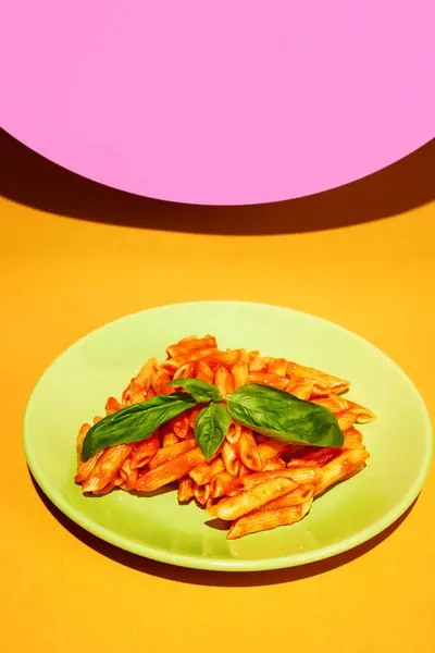 Delicious pasta, penne with tomato sauce and basil decorations over bright colorful background. Restaurant menu. Concept of Italian food, cuisine, taste, cooking, menu. Pop art. Poster, ad