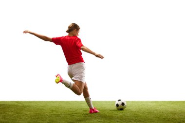 Arkadan bak. Genç bir kız, hareketli bir futbolcu, yeşil çimlerde oynuyor, topa vurmaya hazır, beyaz arka planda. Spor, rekabet, eylem, başarı, motivasyon kavramı. İlan için alanı kopyala