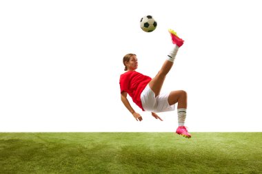 Genç bir kadın, hareketli bir bayan futbolcu, bacağıyla topa vuruyor ve beyaz arka planda çimlere gömülüp düşüyor. Spor, rekabet, aksiyon, başarı, kazanma kavramı. İlan için alanı kopyala