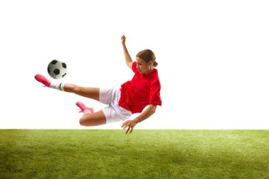 Genç kızın dinamik görüntüsü, futbolcu eğitimi, beyaz arka planda top sektirme çalışması. Spor, rekabet, eylem, başarı, motivasyon kavramı. İlan için alanı kopyala