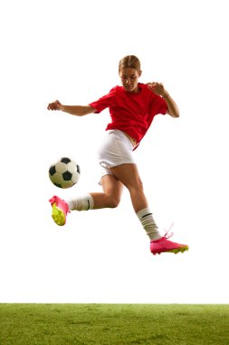 Genç bir kızın tam boy görüntüsü. Futbolcu, beyaz arka planda izole bir şekilde bacaklarıyla top sürüyor. Spor, rekabet, eylem, başarı, motivasyon kavramı. İlan için alanı kopyala