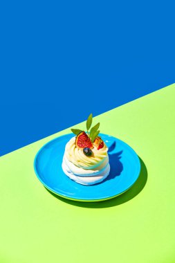 Lezzetli tatlı tabağı ve mavi yeşil arka planda taze böğürtlen. Popüler tatlı. Yemek, tatlı, doğum günü kutlaması. Pop sanat tarzı. Reklam için boşluk kopyala. Poster