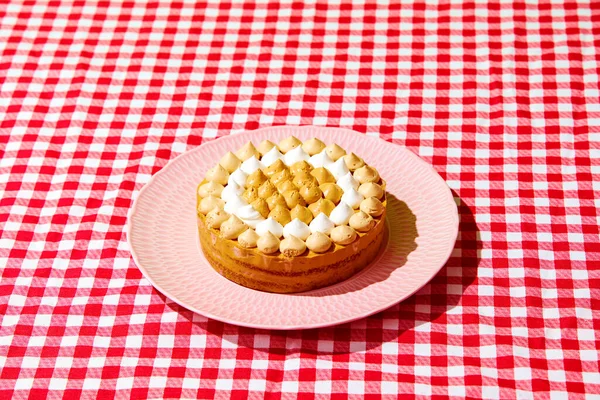 Sweet, delicious pie with cream isolated on checkered tablecloth. Close-up. Concept of food, desserts, birthday celebration, party, bakery. Pop art style. Copy space for ad. Poster