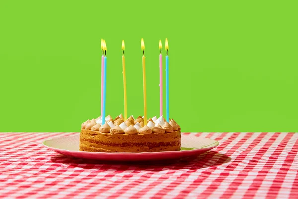 Sweet, delicious creamy pie, cake with birthday candles isolated on checkered tablecloth over green background. Concept of food, desserts, birthday celebration, party, bakery. Pop art style. Poster