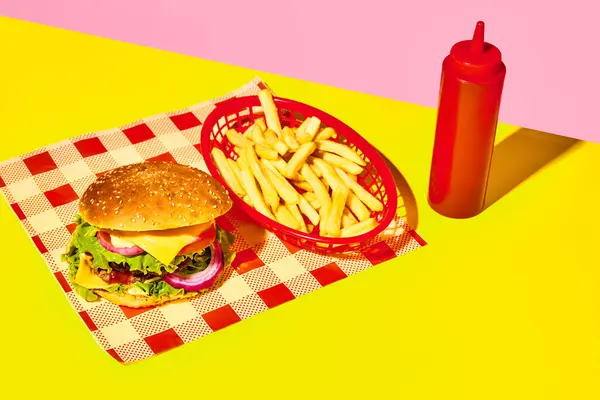 Delicious burger, hamburger with meat, cheese, lettuce and tomato with fries and ketchup on napkin over yellow background. Concept of fast food, taste, junk food. Complementary colors. Poster, ad