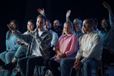 Bir grup insan, iş arkadaşları toplantıya katılıyor, konferans veriyor, brifing veriyor, profesyonel sorular soruyor. İş, eğitim, ortaklık, koçluk, girişimcilik kavramı