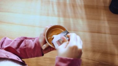 Latte sanatı. Kadın barista çalışanı cappuccino yapıyor, latte içiyor, taze espressoya buğulanmış süt döküyor. Kahve endüstrisi kavramı, meslek, zevk, kahve dükkanı, kafeterya, iş dünyası