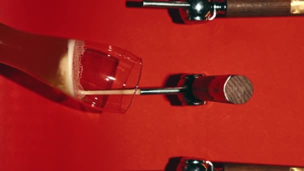 バーテンダーはゆっくりと赤い背景に対してガラスに美味しいラガー泡立ったビールを注いでいます バブルス ビールバー リラックス 飲み物 醸造所 飲み物質の概念 垂直レイアウト — ストック動画