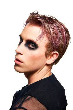 Pembe boyalı saçlı, dumanlı gözlü beyaz stüdyo arka planında poz veren genç bir adam portresi. Erkek makyaj anlayışı, moda, lgbtq topluluğu, kişisel kimlik, kabullenme