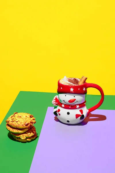 Mug in image of snowman filled with delicious hot drink, cocoa, coffee with whipped cream and cinnamon on colorful background. Concept of winter season, Christmas holidays, traditional drinks. Poster