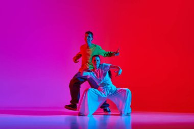 Genç yetenekli insanlar, sokak dansı yapan kadın ve erkek, neon ışıkta pembe arka planda hip hop. Hobi, eylem, sokak tarzı, modern dans, gençlik, moda kavramı