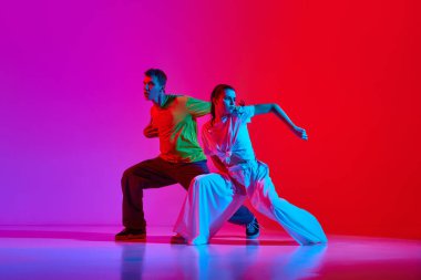 Genç yetenekli insanlar, sokak dansı yapan kadın ve erkek, neon ışıkta pembe arka planda hip hop. Hobi, eylem, sokak tarzı, modern dans, gençlik, moda kavramı