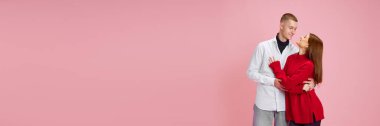 Genç insanlar, erkek ve kadın, pembe stüdyo arka planında kucaklaşan sevimli bir çift. Aşk kavramı, ilişki, Sevgililer Günü, duygular, yaşam tarzı. Metin eklemek için boş boşluk