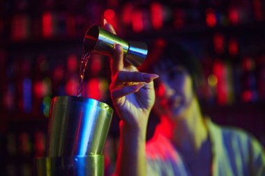 Genç, güzel bir kadın, barmen kokteyl yapıyor, barda çalışıyor, zencefilden karıştırıcıya sıvı döküyor, malzemeleri karıştırıyor. Meslek kavramı, gece hayatı, bar, parti, alkol içeceği, mixolog